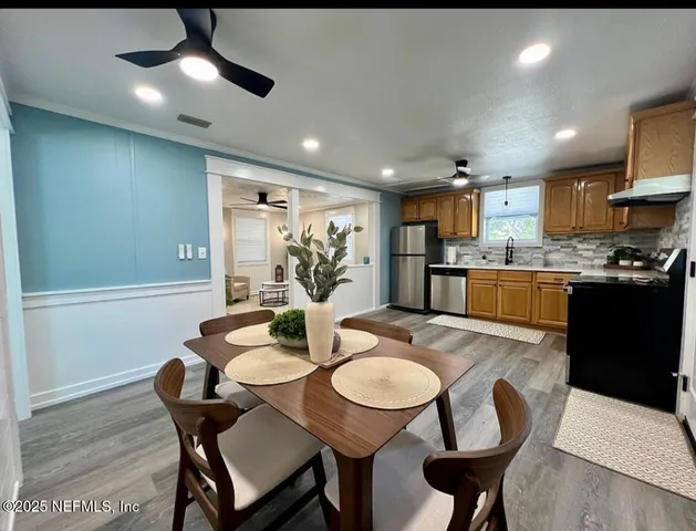 a view of a dining room with furniture a kitchen and chandelier
