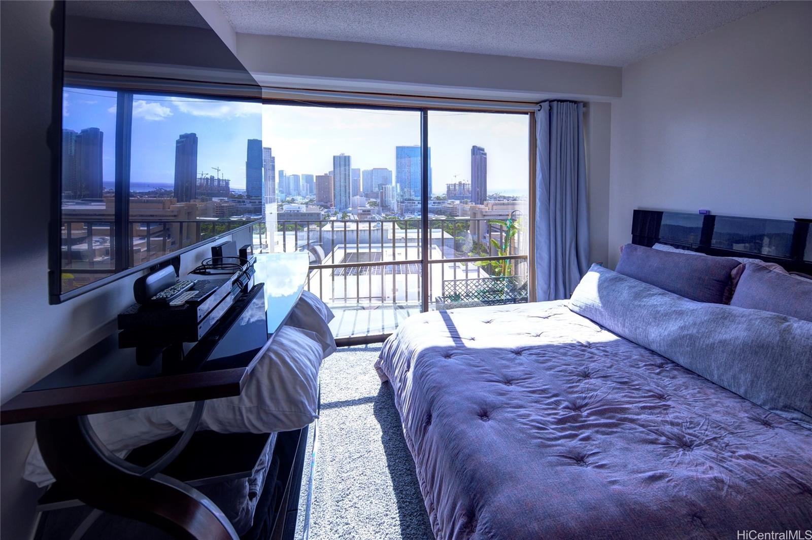 700 Richards Street, Unit 1708 Honolulu, HI 96813 - Photo 18 of 25 a large bedroom with a bed and glass window