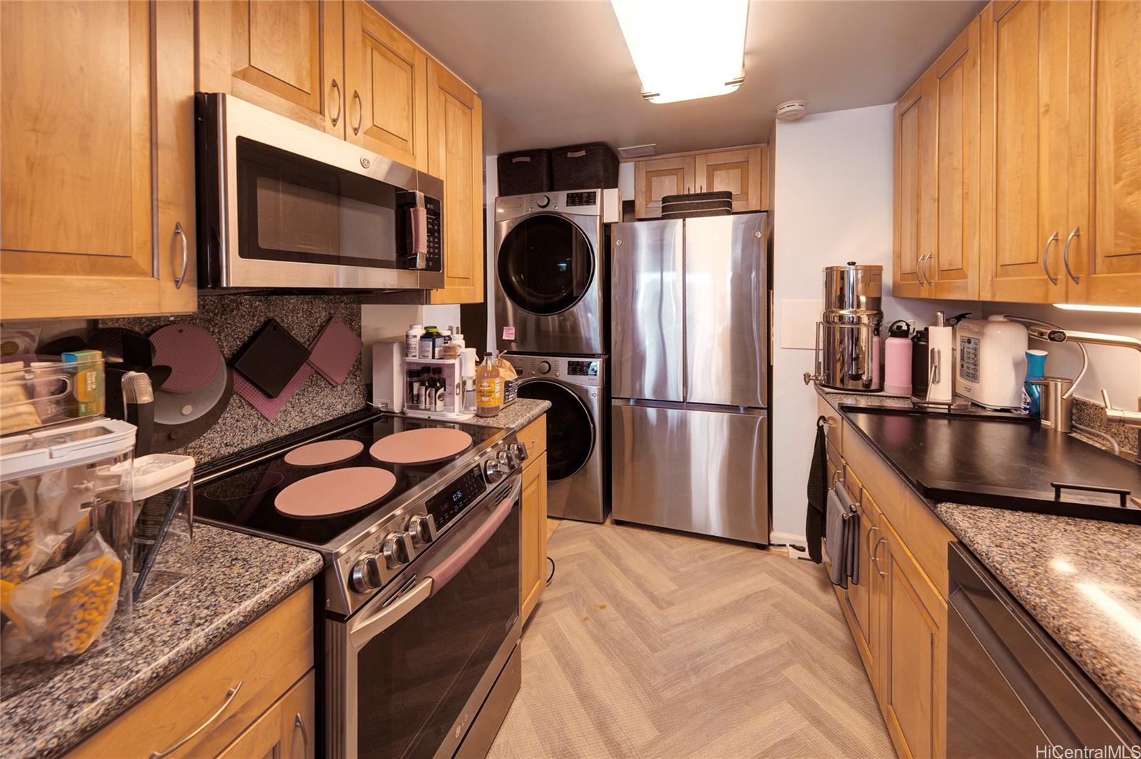 700 Richards Street, Unit 1708 Honolulu, HI 96813 - Photo 2 of 25 a kitchen with granite countertop a sink a stove top oven and refrigerator