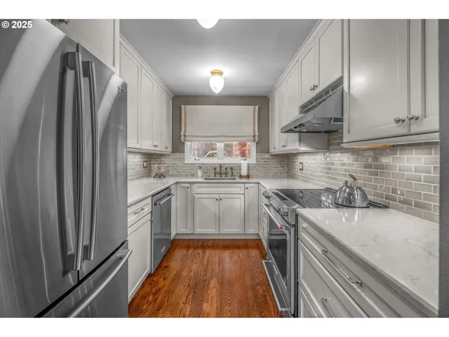 a kitchen with stainless steel appliances granite countertop a refrigerator sink and stove