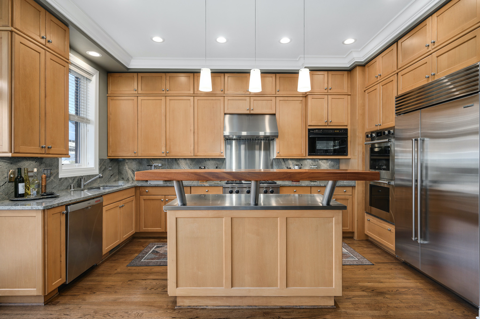 481 North Canal Street Chicago, IL 60654 - Photo 10 of 50 a kitchen with kitchen island granite countertop a stove a sink a refrigerator and a microwave