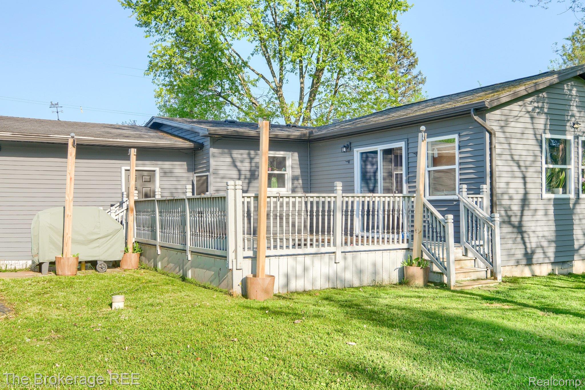 6288 Porter Road Grand Blanc, MI 48439 - Photo 6 of 39 Rear view of house featuring a yard and a wooden deck
