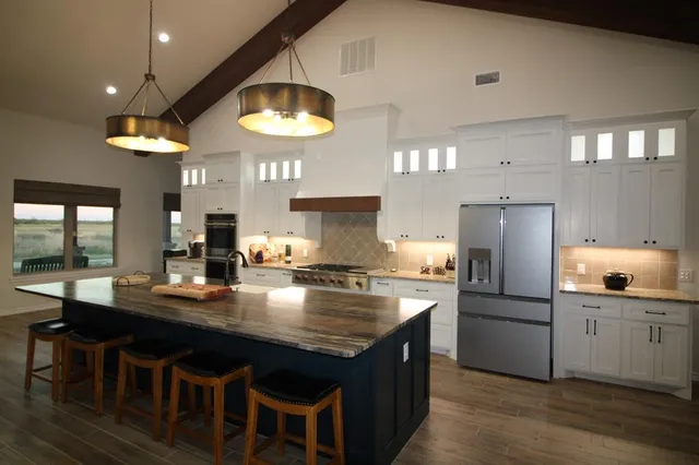 a kitchen with stainless steel appliances granite countertop a sink a stove and refrigerator