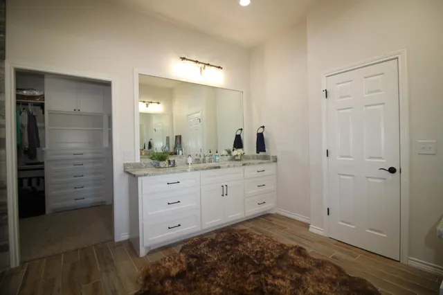 a bathroom with a granite countertop sink and a mirror