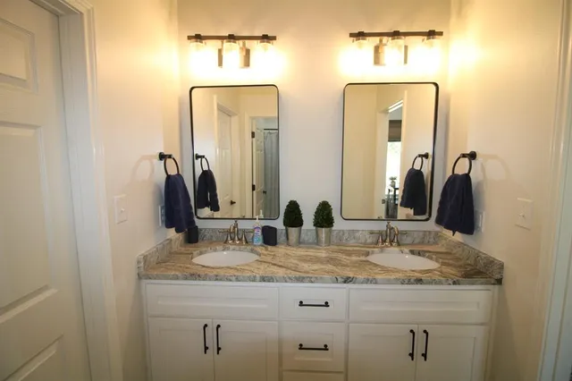 a bathroom with a granite countertop sink vanity and mirror