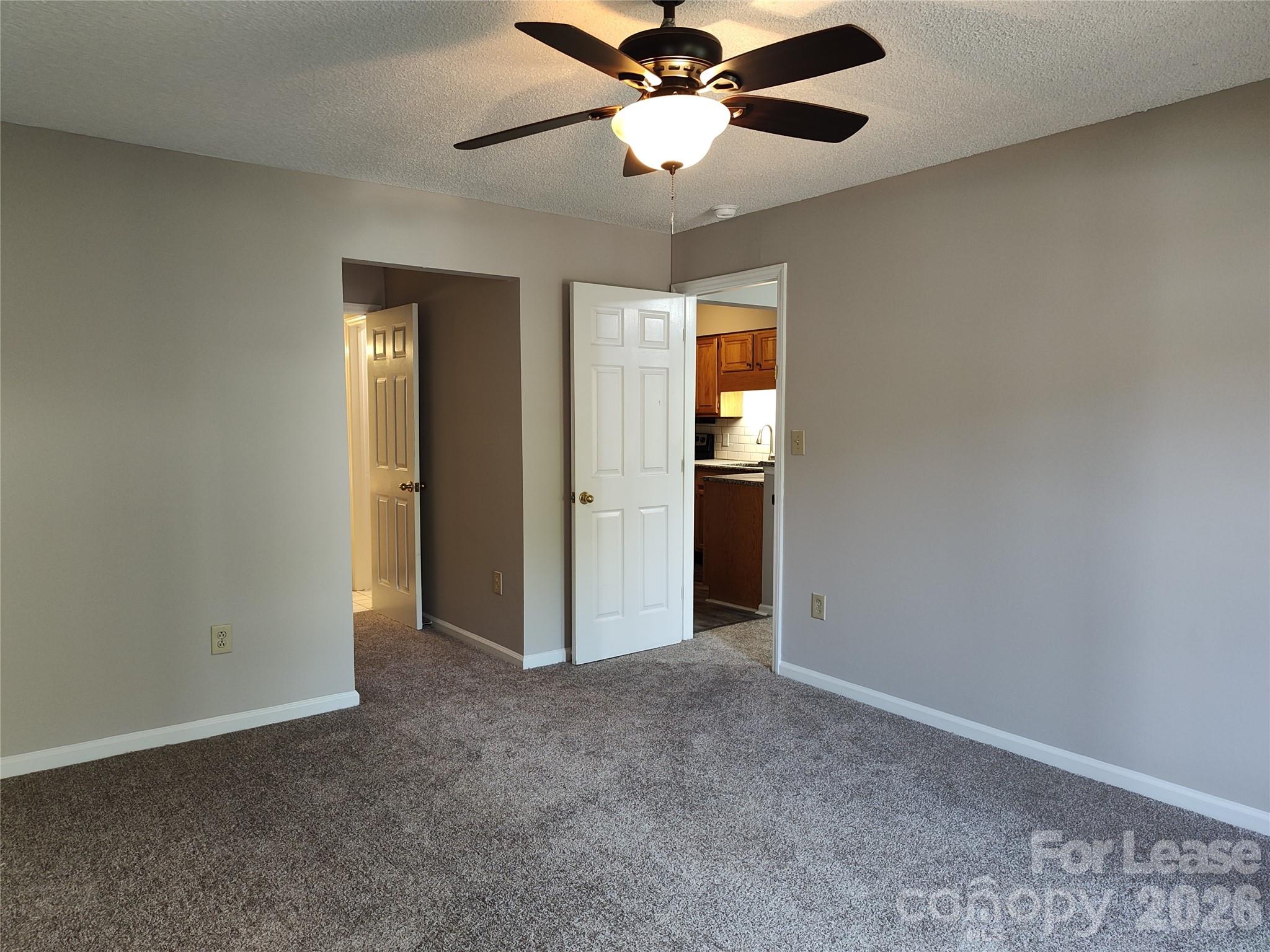 5001 Sharon Road, Unit K Charlotte, NC 28210 - Photo 16 of 24 an empty room with closet and a chandelier fan