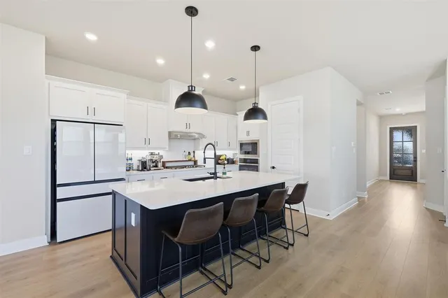 a kitchen with stainless steel appliances kitchen island granite countertop a sink a counter top space and cabinets