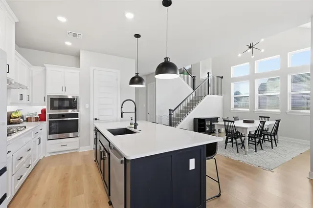 a kitchen with granite countertop a sink a stove and chairs