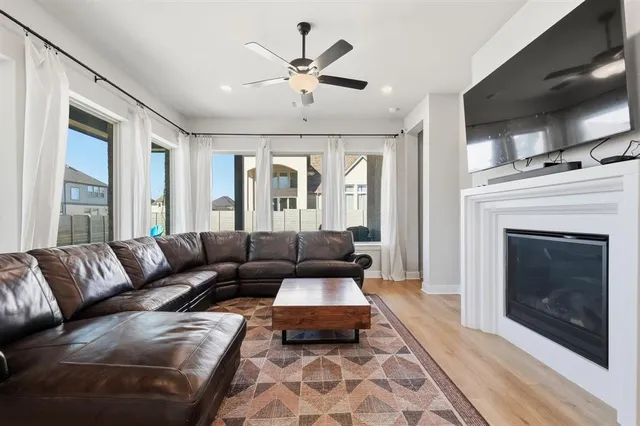 a living room with furniture a flat screen tv and a fireplace
