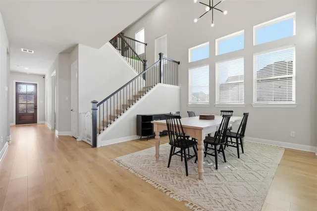 a kitchen with stainless steel appliances kitchen island granite countertop a sink a stove a refrigerator and white cabinets with wooden floor