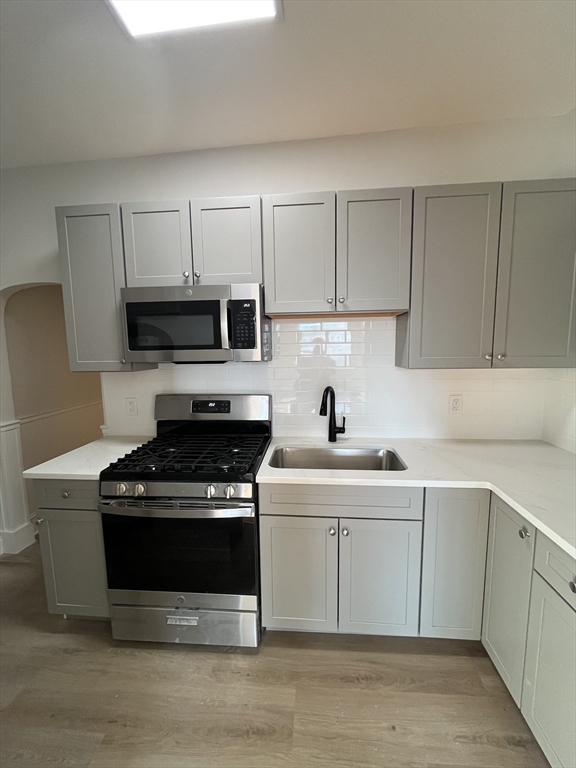 108 Bristol Road, Unit 1 Somerville, MA 02144 - Photo 5 of 24 a kitchen with cabinets stainless steel appliances and a sink