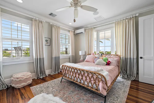 a spacious bedroom with a bed and wooden floor