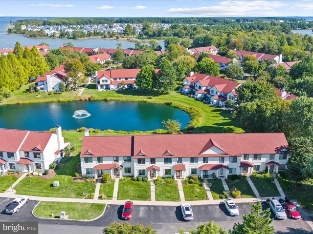 an aerial view of a house with a garden and lake view