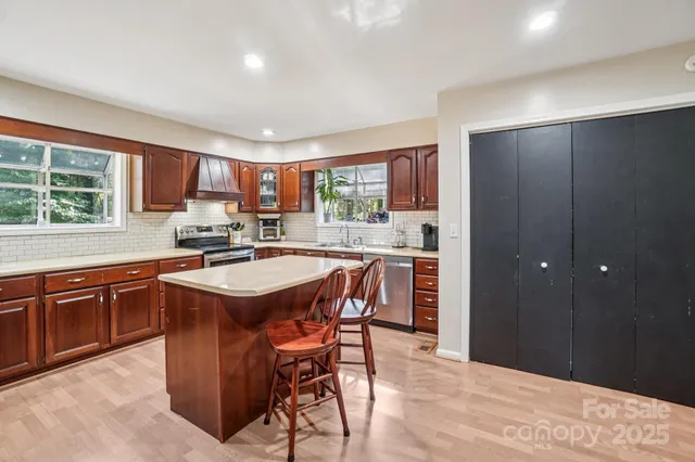 a kitchen with stainless steel appliances a sink stove and cabinets