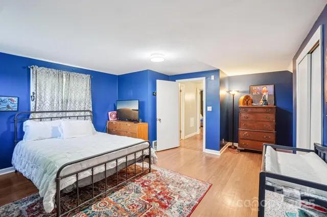 a bedroom with a bed and wooden floor