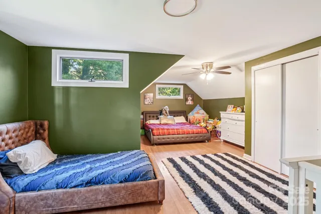 a bedroom with a bed window and a chandelier