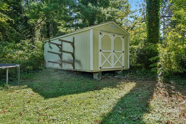 a front view of house with a garden and trees