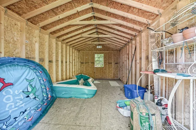 a backyard of a house with large trees and plants