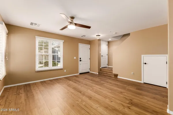 a view of an empty room with wooden floor and a window