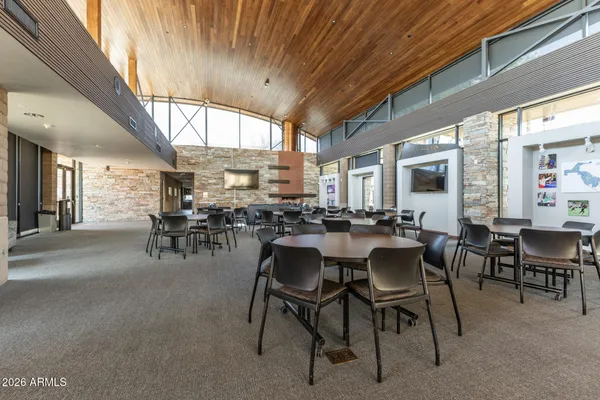 a dining hall with furniture and a large window