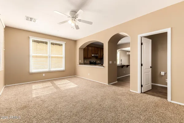 a view of a big room with windows and chandelier fan