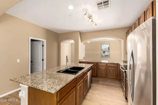 a kitchen with stainless steel appliances granite countertop a sink stove and refrigerator