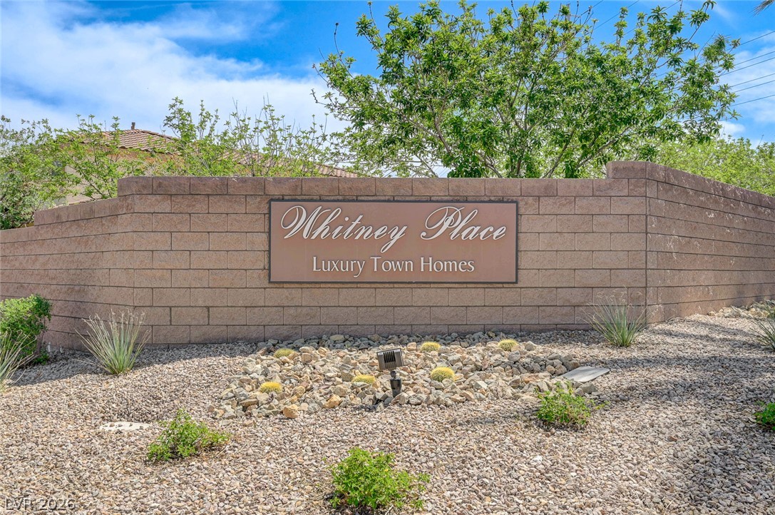 1479 Orange Jubilee Road Henderson, NV 89014 - Photo 35 of 36 An inviting entry to a residential community, featuring a stone wall with a prominent sign and desert landscaping.