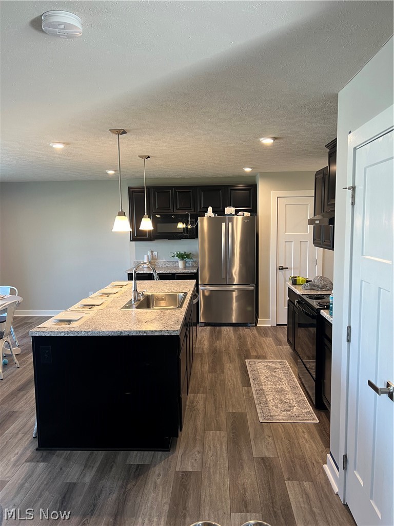 15012 Decourcey Rittman, OH 44270 - Photo 6 of 26 Kitchen featuring stainless steel fridge, range, a center island with sink, sink, and dark hardwood / wood-style floors