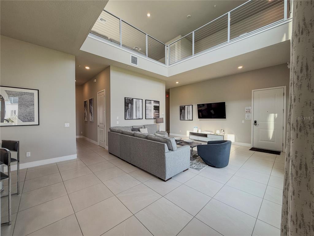 7770 Sandy Ridge Drive, Unit 231 Reunion, FL 34747 - Photo 3 of 25 a living room with stainless steel appliances furniture a flat screen tv and a refrigerator