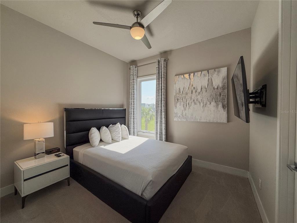 7770 Sandy Ridge Drive, Unit 231 Reunion, FL 34747 - Photo 10 of 25 a bedroom with a bed a couch and a window