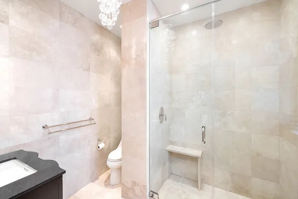 a bathroom with a granite countertop shower and a toilet