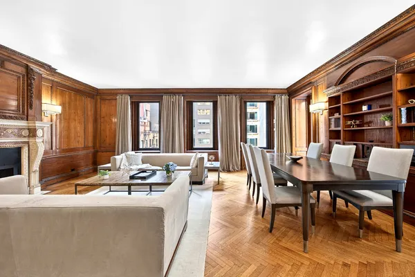 a living room with furniture a fireplace and large windows