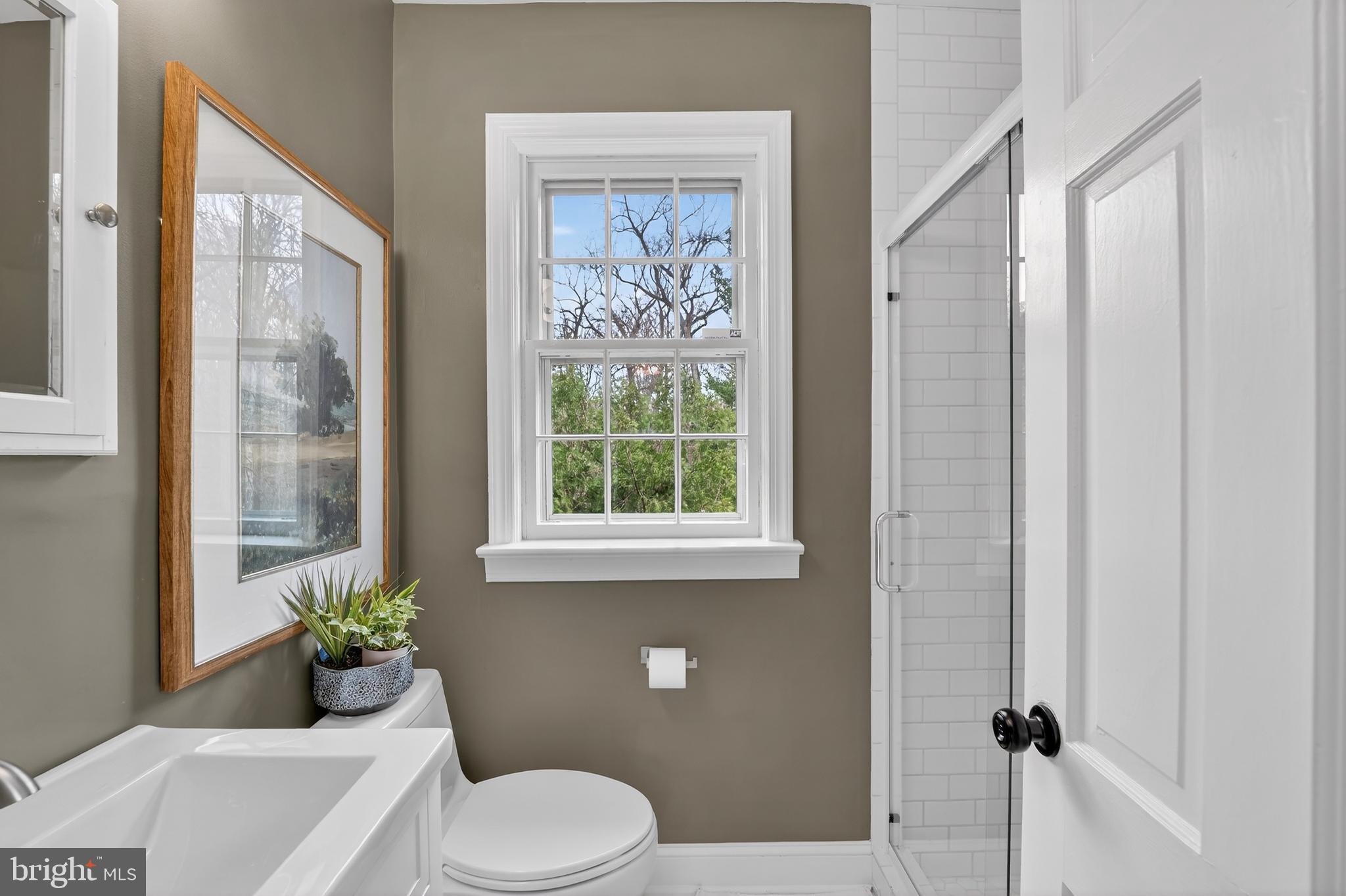 5445 30th Street Northwest Washington, DC 20015 - Photo 24 of 46 a white toilet sitting next to a bathroom sink and a window