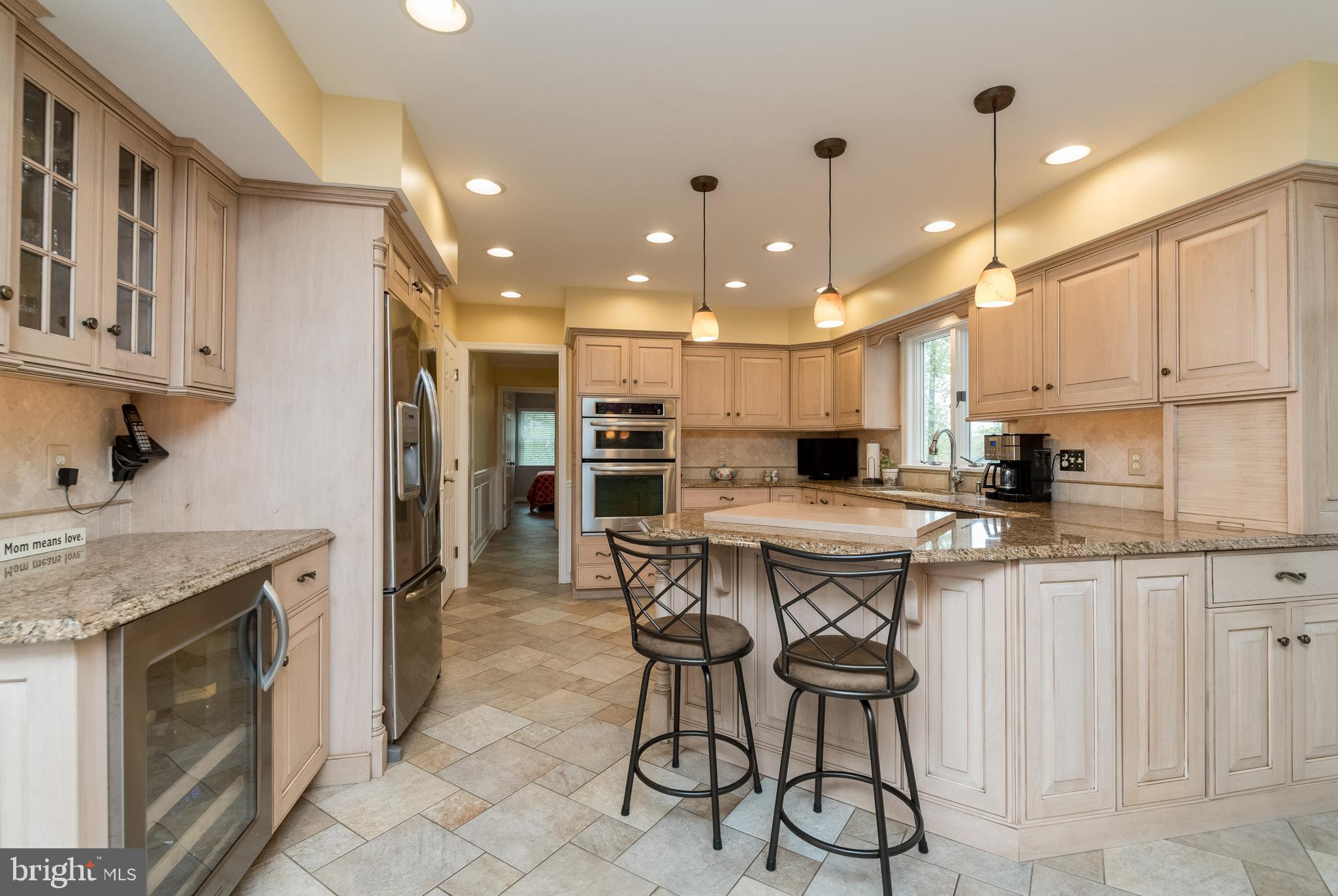 1007 Valewood Road Towson, MD 21286 - Photo 11 of 49 a kitchen with stainless steel appliances kitchen island granite countertop a table chairs sink and cabinets