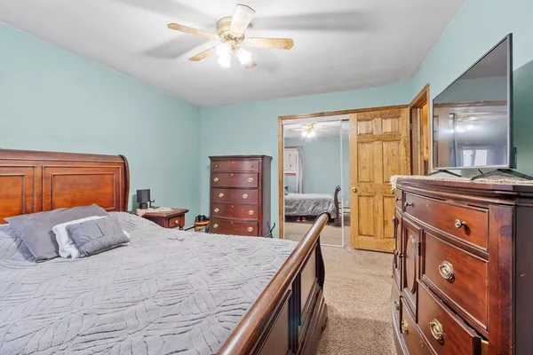 a bedroom with a large bed and a chandelier