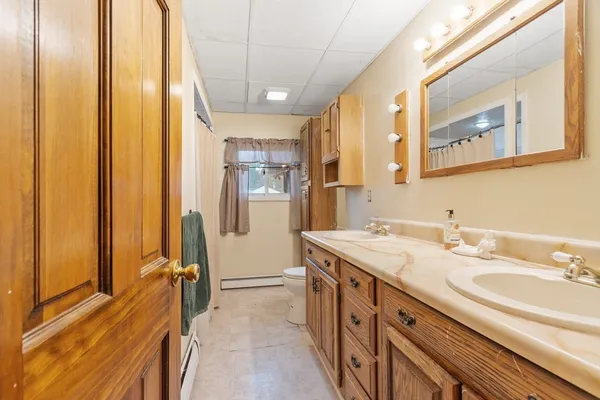 a spacious bathroom with a granite countertop sink a mirror and a shower