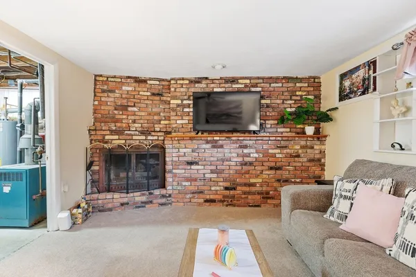 a living room with couches a flat screen tv and a fireplace