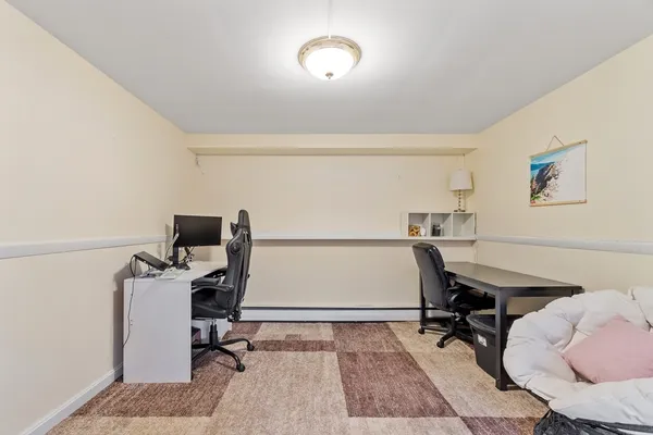 a view of a workspace with furniture and a window