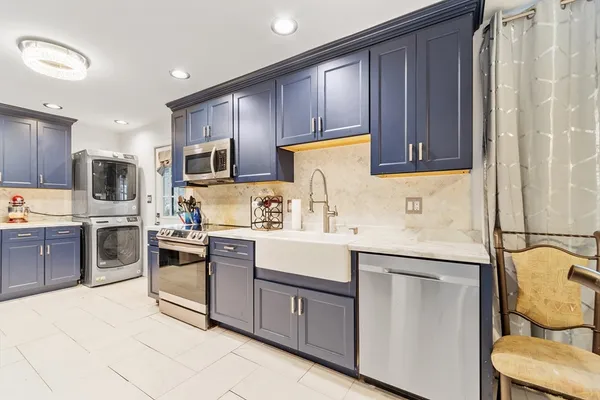 a kitchen with granite countertop appliances a sink and cabinets