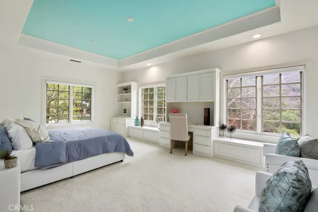 a spacious bedroom with a bed couch and large window