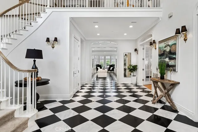 a view of a hallway with a black white checkered floor and a white table with chairs