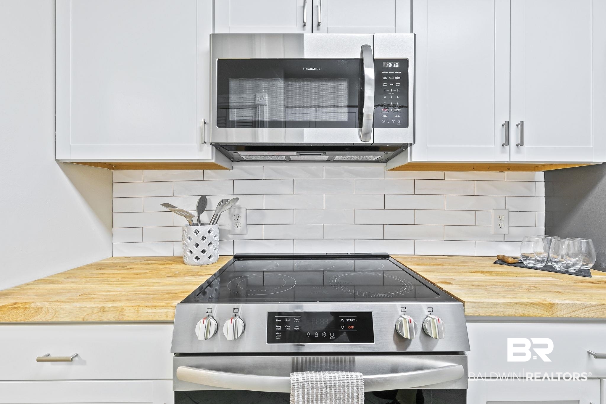 110 5th Street, Unit C103 Daphne, AL 36526 - Photo 20 of 46 Kitchen with stainless steel appliances, white cabinets, tasteful backsplash, and butcher block counters