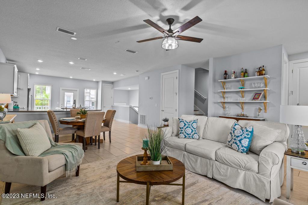 a living room with furniture kitchen view and a potted plant