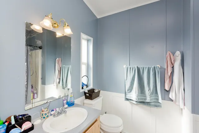 a bathroom with a sink vanity mirror and toilet