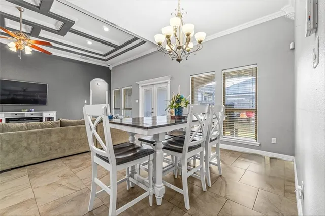a dining room with furniture a chandelier and window