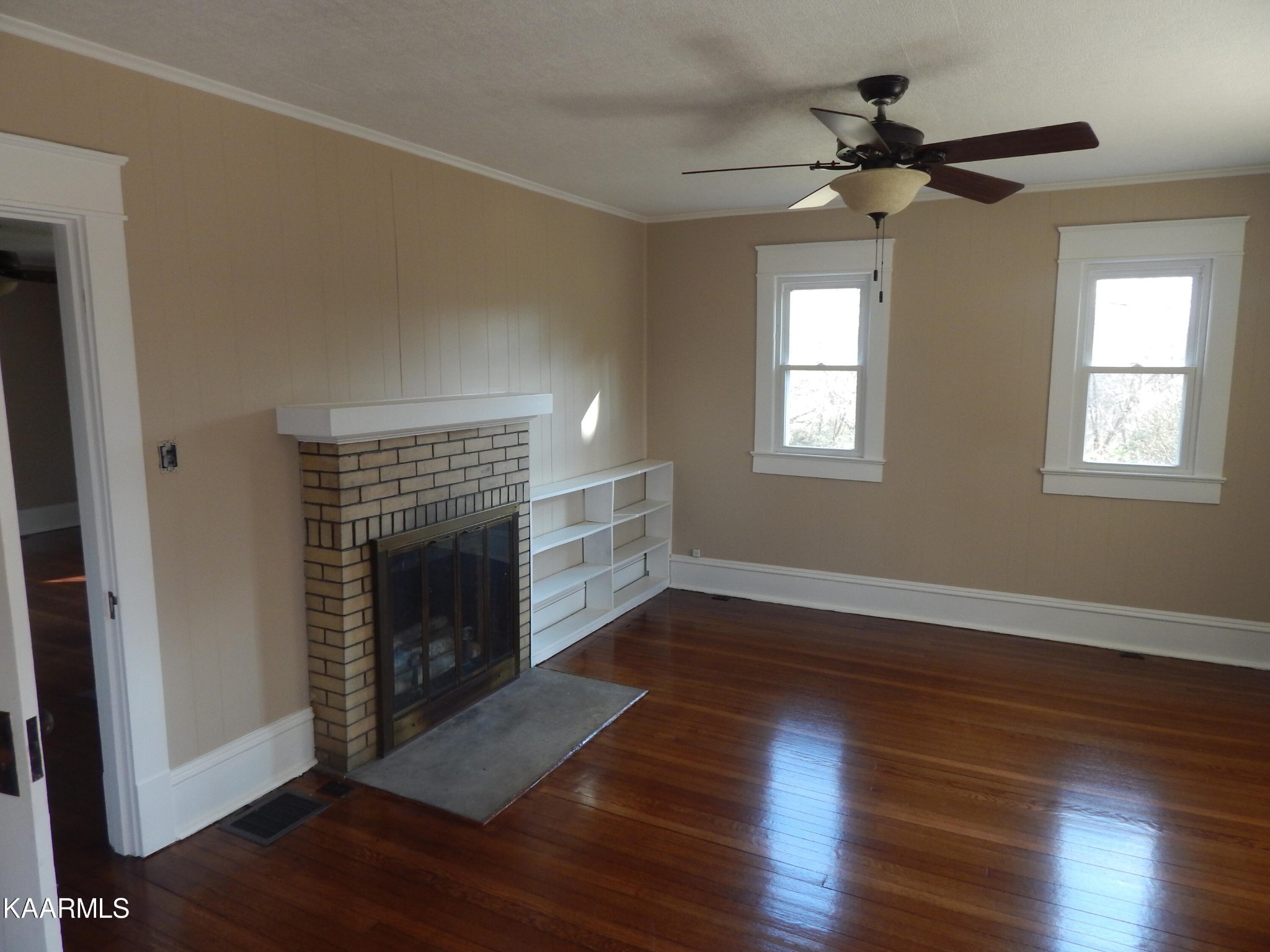 367 Reed Road Greeneville, TN 37745 - Photo 18 of 51 an empty room with wooden floor fireplace and windows