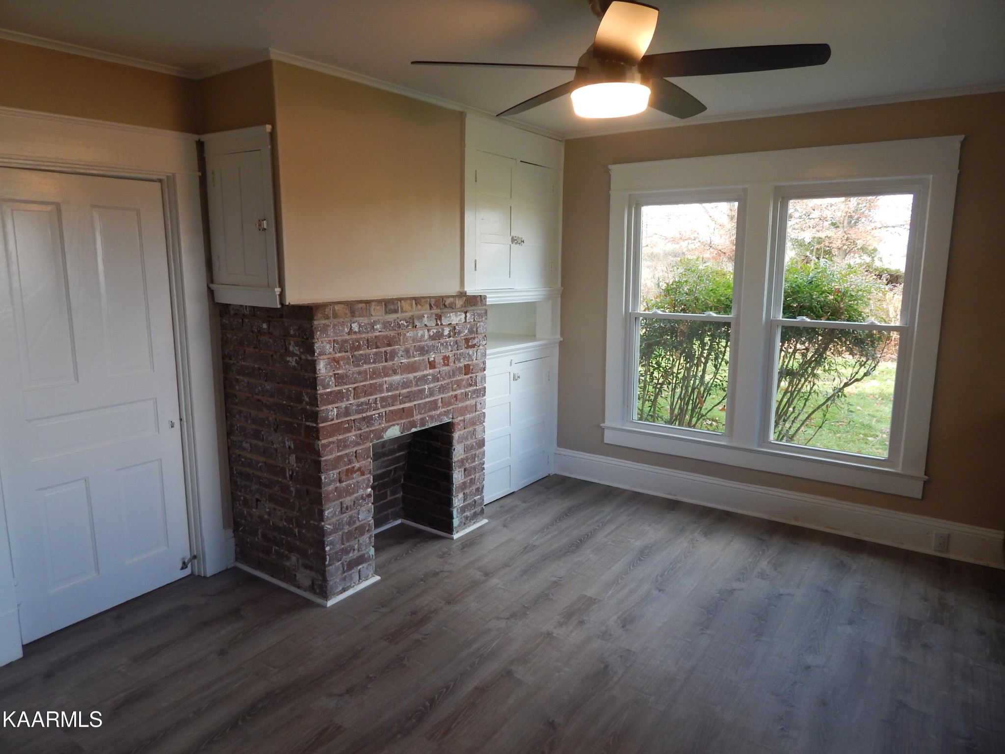 367 Reed Road Greeneville, TN 37745 - Photo 32 of 51 an empty room with wooden floor fireplace and windows