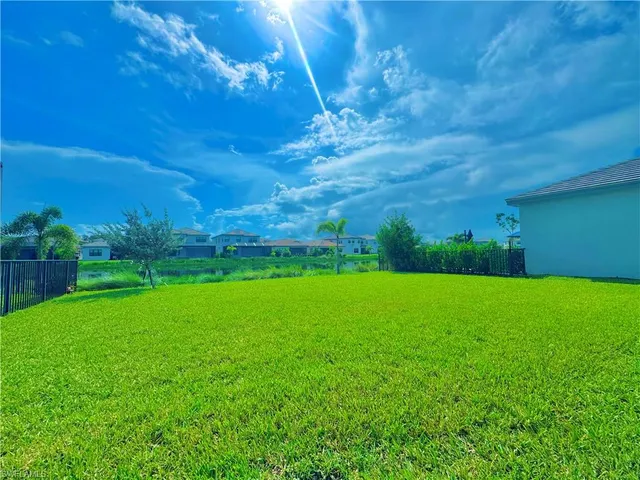 a kitchen with stainless steel appliances granite countertop a sink a stove a refrigerator and white cabinets