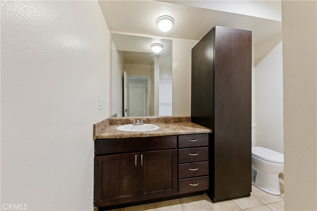 1517 East Garfield Avenue, Unit 53 Glendale, CA 91205 - Photo 27 of 53 a bathroom with a granite countertop sink a toilet and a mirror