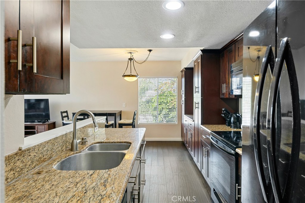 1517 East Garfield Avenue, Unit 53 Glendale, CA 91205 - Photo 3 of 53 a kitchen with kitchen island granite countertop a sink stainless steel appliances and cabinets